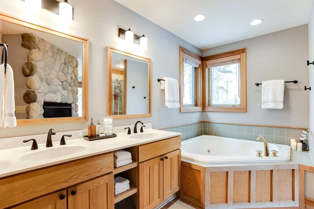 Spa bathroom with double vanity and corner soaking tub