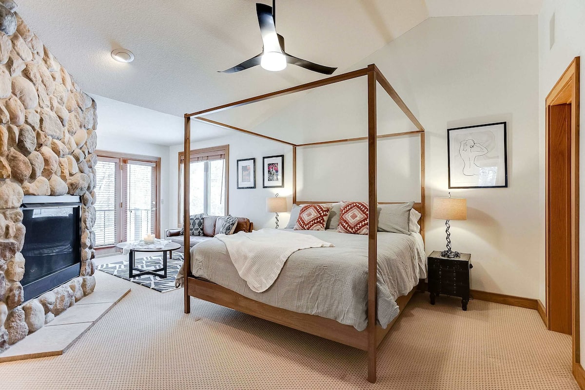 Master bedroom with four-poster king bed and stone fireplace
